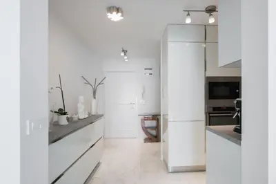 a white kitchen with white cabinets and a refrigerator at AB Ljubljana - The Princess Castle Triplex in Ljubljana