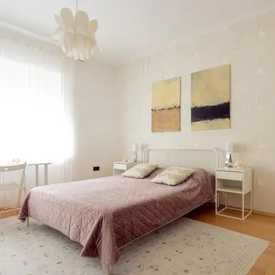a white bedroom with a bed and a chandelier at Large Two Bedroom Family APP - free parking in Ljubljana