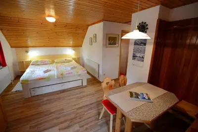 a small bedroom with a bed and a table at Apartmaji Zupančič in Bohinj