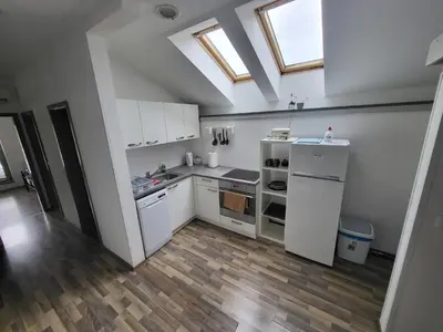 a kitchen with white appliances and a skylight at Hiša 2 in Tolmin