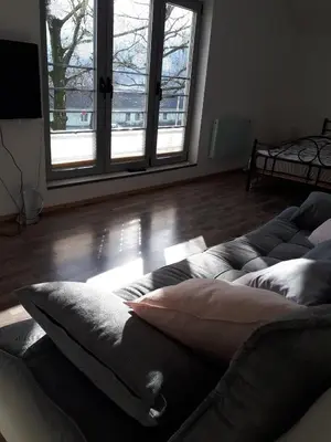 a living room with a couch with pillows on the floor at Hiša 2 in Tolmin