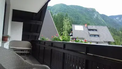 a balcony with a view of a house and mountains at Apartmaji Vesna in Bohinj