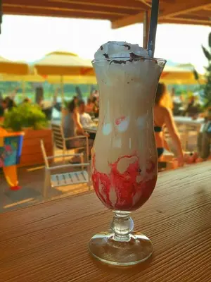 a drink in a glass sitting on a table at Green Resort Glamping in Radlje ob Dravi