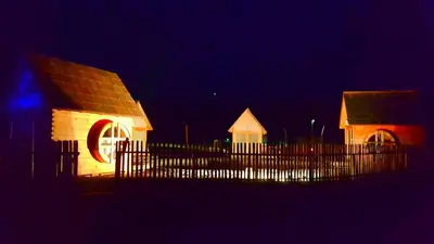 a building with a fence in front of it at night at Green Resort Glamping in Radlje ob Dravi