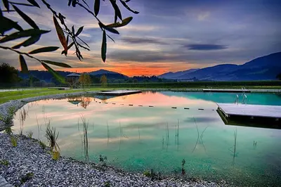 a large pool of water with a sunset in the background at Green Resort Glamping in Radlje ob Dravi