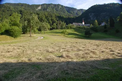 a field of grass with a house in the background at Chalet ApArt Kupljenik 12 A, Bled in Bohinjska Bela
