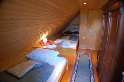 a room with two beds and a table with a lamp at Chalet ApArt Kupljenik 12 A, Bled in Bohinjska Bela