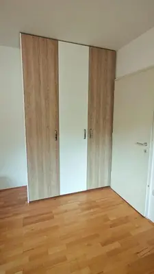 an empty room with two doors and wooden floors at Cozy little nest, Bled region in Jesenice