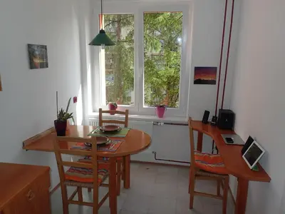 a dining room with a table and chairs and a window at Cozy little nest, Bled region in Jesenice