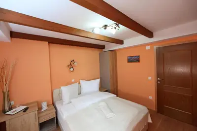 a bedroom with a white bed and a wooden door at Sobe Grabar in Ptuj