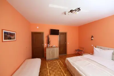 two beds in a room with orange walls at Sobe Grabar in Ptuj