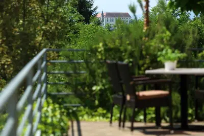 a patio with two chairs and a table with a plant at Sobe Grabar in Ptuj