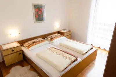 a bedroom with two beds and a window at Apartment pri Damijanu in Ponikve