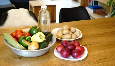 three bowls of fruits and vegetables on a wooden table at ecoHouse FURLAN - Apartment PINJA in Kobarid