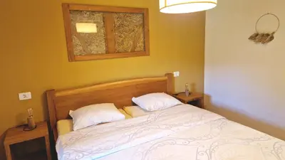 a bedroom with a bed with two pillows and a window at ecoHouse FURLAN - Apartment PINJA in Kobarid