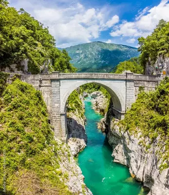 a bridge over a river with green water at ecoHouse FURLAN - Apartment PINJA in Kobarid