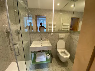 a bathroom with a toilet and a sink and a mirror at Isabella Living in Maribor