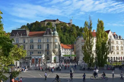 a group of people walking around a city with buildings at Studio Optim in Ljubljana