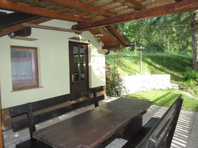 a wooden bench sitting outside of a house at Apartma Narnia in Bovec