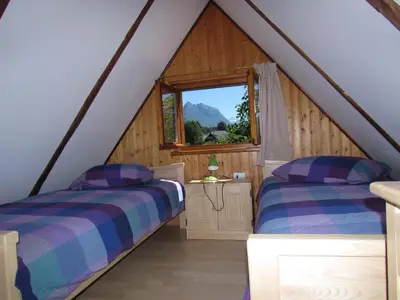 two beds in a attic room with a window at Apartma Narnia in Bovec