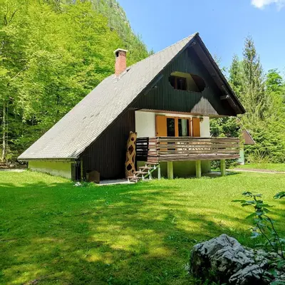 a small house with a roof on a grass field at Chalet Via Mons in Mojstrana