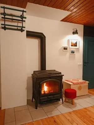 a fireplace in a living room with a stove at Chalet Via Mons in Mojstrana