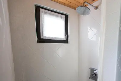 a bathroom with a shower with a window on the wall at Slabnik Nature Escape in Idrija