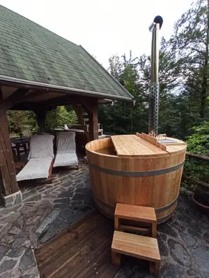 a wooden tub sitting on a patio with a gazebo at Slabnik Nature Escape in Idrija