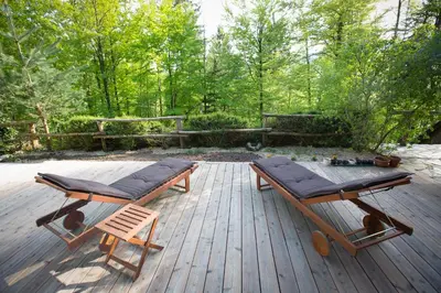 a wooden deck with two chairs and a picnic table at Slabnik Nature Escape in Idrija