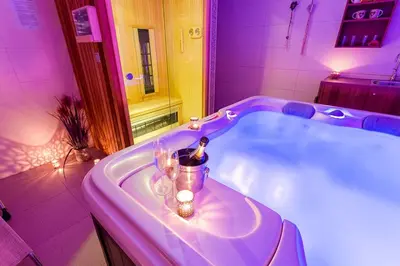 a purple bathroom with a tub with candles in it at Villa Aina Boutique Hotel in Laško