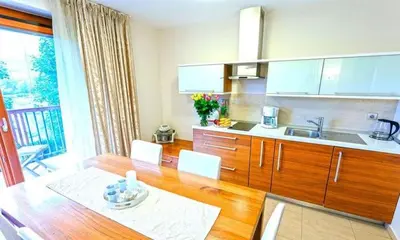 a kitchen with a wooden table and a kitchen with a sink at Villa Aina Boutique Hotel in Laško