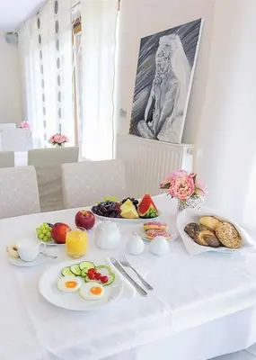 a white table with plates of food on it at Villa Aina Boutique Hotel in Laško
