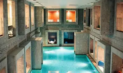 a large swimming pool in a building with blue water at Villa Aina Boutique Hotel in Laško