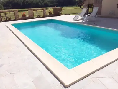 a swimming pool with blue water in a backyard at Tourist Farm Mali Raj in Dolenci
