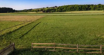 a wooden bench in a field with a fence at Tourist Farm Mali Raj in Dolenci