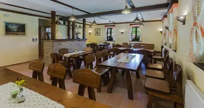 a restaurant with wooden tables and chairs in a room at Tourist Farm Mali Raj in Dolenci