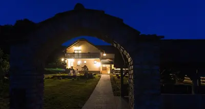 an archway leading to a building at night at Tourist Farm Mali Raj in Dolenci