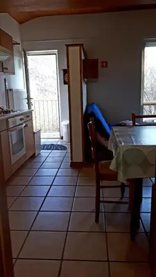 a kitchen with a table and a table and a room at Apartma NADIŽA in Borjana