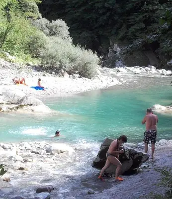 a group of people standing on a rock in a river at Apartma NADIŽA in Borjana