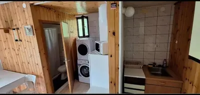 a small kitchen with a refrigerator and a washer at Apartma NADIŽA in Borjana