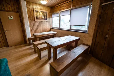 a room with wooden tables and benches in a room at Hostel Paradiso in Tolmin