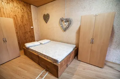 a bed in a room with two doors and a heart on the wall at Hostel Paradiso in Tolmin