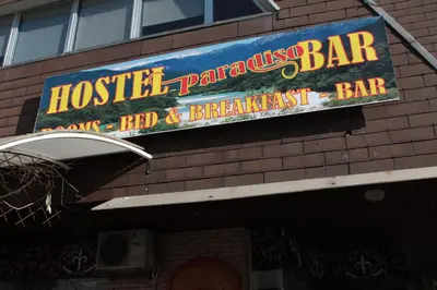 a sign on the side of a restaurant at Hostel Paradiso in Tolmin