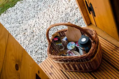 a wicker basket sitting on a wooden bench at Glamping FOREST EDGE in Kamnik