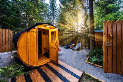 a small wooden cabin with the sun in the background at Glamping FOREST EDGE in Kamnik