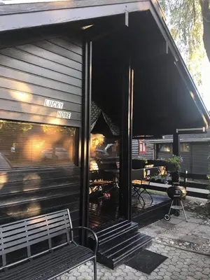 a black building with a bench in front of it at Lucky home in Čatež ob Savi