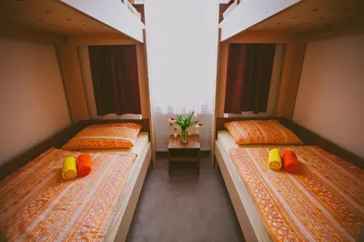 two twin beds in a room with windows at Hotel & Hostel Marenberg Radlje in Radlje ob Dravi