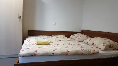 a bed with a blanket and pillows on it at Hotel & Hostel Marenberg Radlje in Radlje ob Dravi