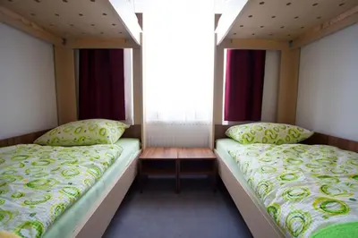 a bedroom with two beds and a window at Hotel & Hostel Marenberg Radlje in Radlje ob Dravi