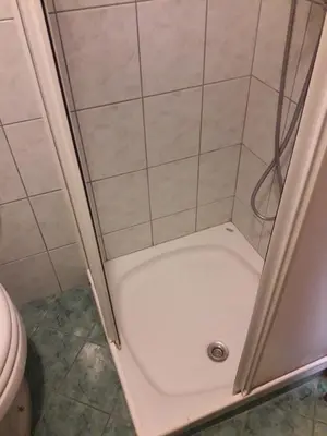 a shower with a white floor and a shower stall at D-D in Bovec